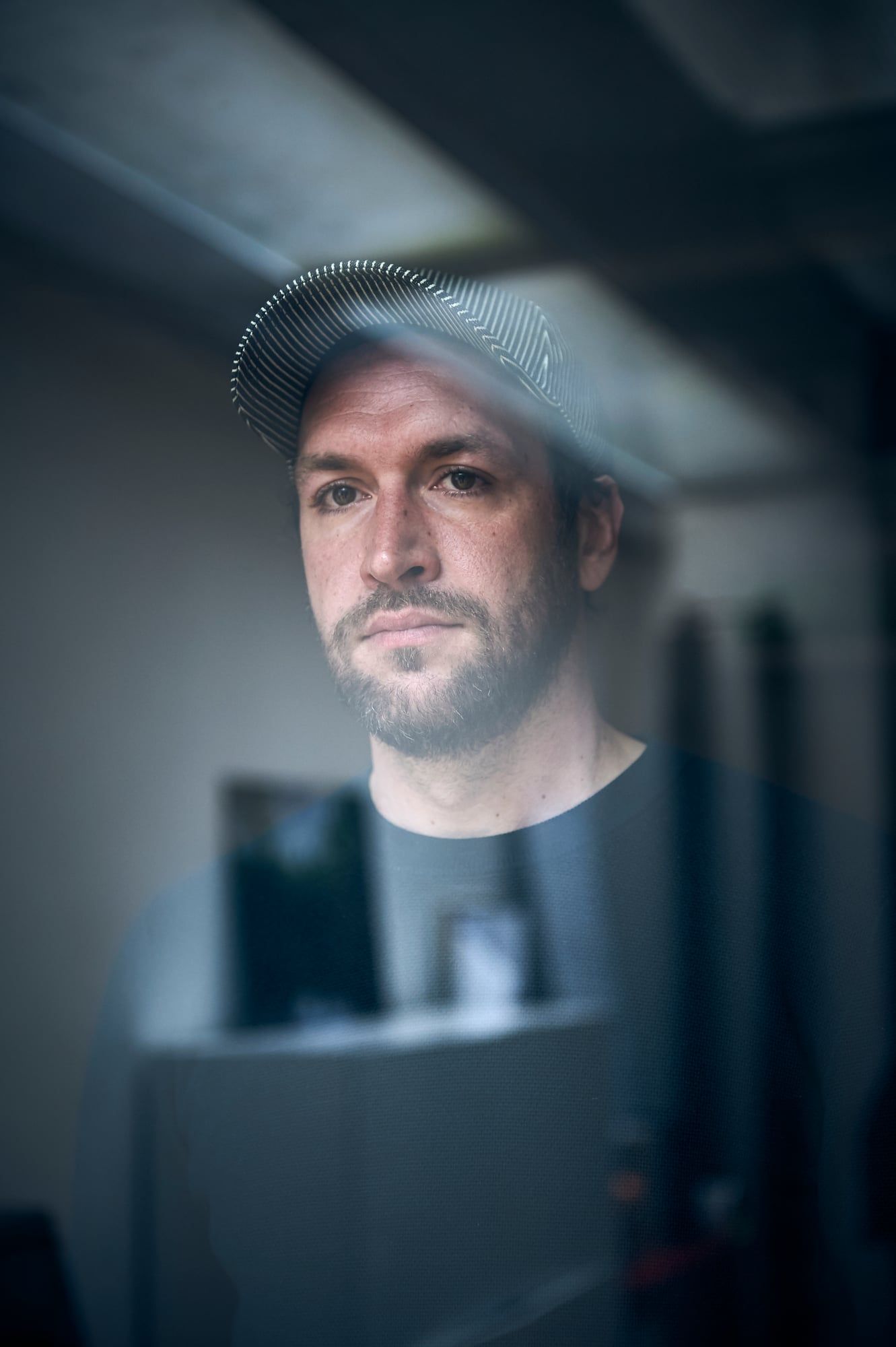 Portrait de Pierre Nouvel, de face, derrière une vitre
